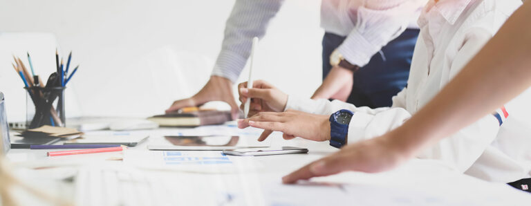 Ein Team von Mitarbeitern plant am Tisch das Lichtkonzept.